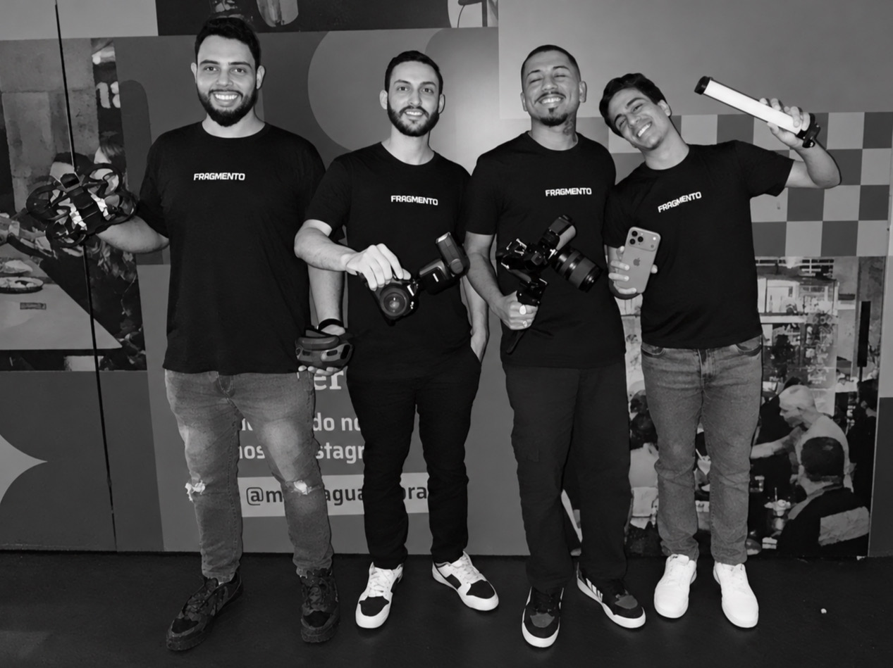 Equipe da Fragmento Produtora reunida com câmeras, drone e iluminação, em preto e branco.
